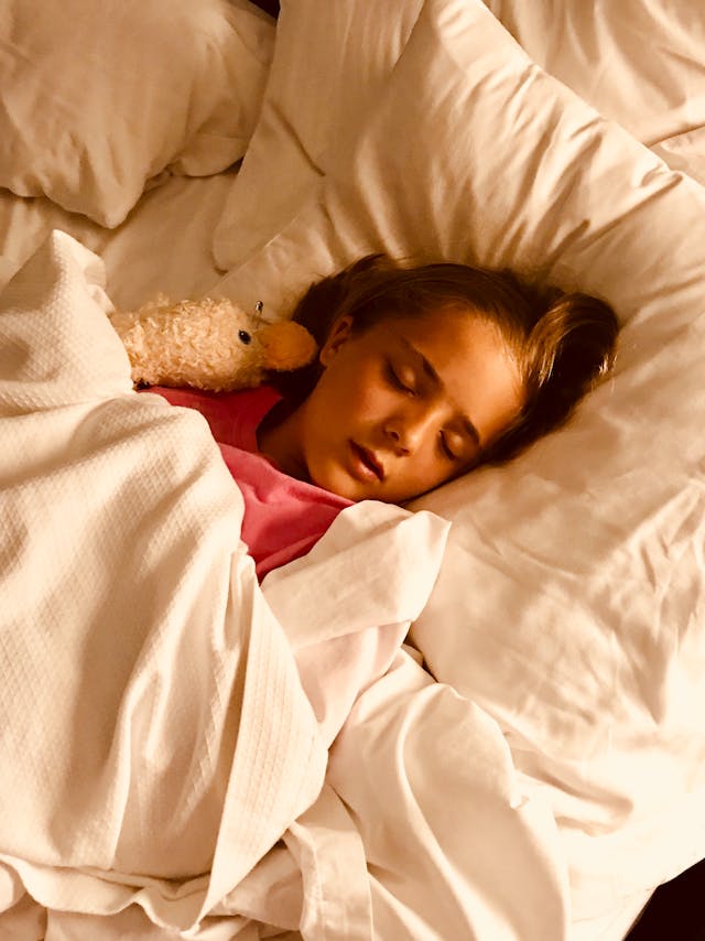 child sleeping in bed with slightly open mouth